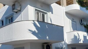 A multi-story building with balconies, air conditioning units, and windows. - Vila REJANA (Ksamil)
