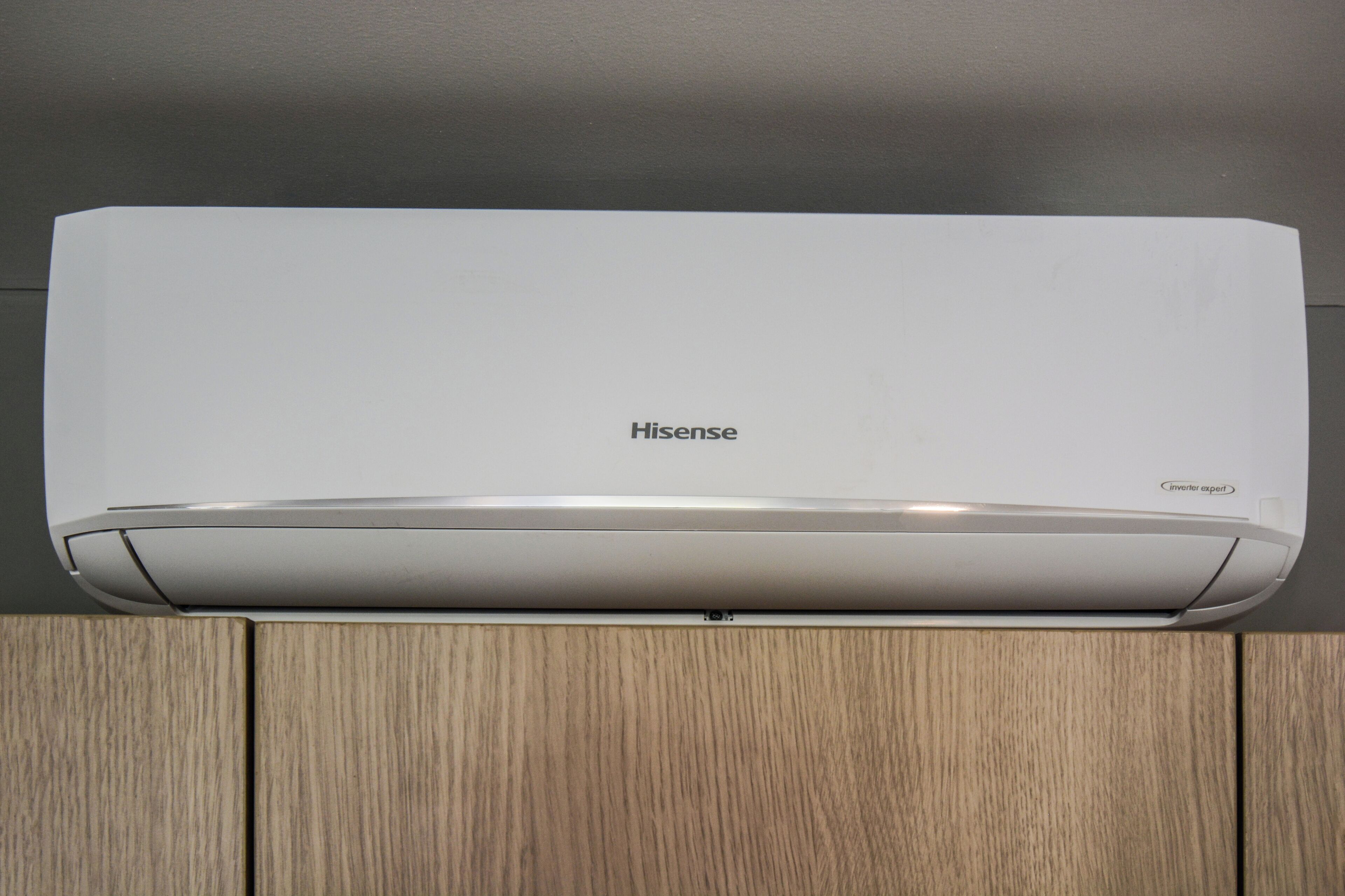 Eine Hisense Inverter Expert Klimaanlage, montiert an einem Holzschrank.