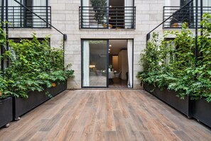 Ein modernes Gebäude mit Holzboden, großen Glasüren und schwarzen Metallgeländern.