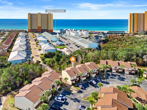 Zona hotelera frente al mar, con acceso directo a la playa, varios edificios, estacionamientos y vista despejada del océano.