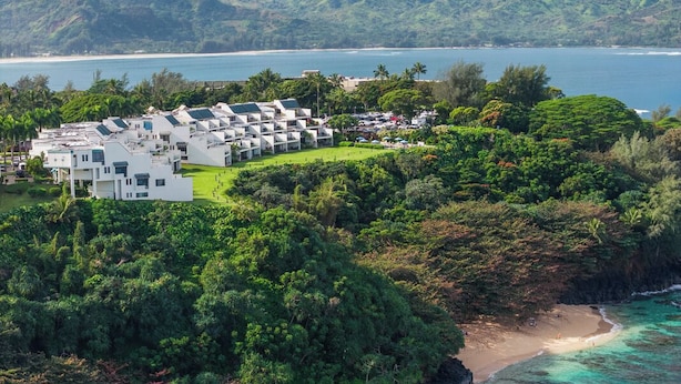 A resort with multiple white buildings, a beachfront, and lush greenery. - Puu Poa 102 - Private and Serene 2/2 with ocean views (Princeville)