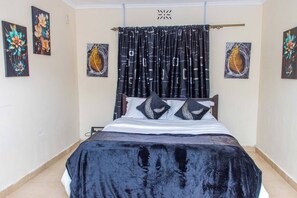A bedroom with a bed, black curtains, and wall art. - Charming 4-bedroom bungalow in peaceful Nyeri neighborhood (Nyeri)