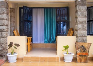 A covered entrance with a wooden bench, two potted plants, and a sign reading "KEYMAN ADDRESS". - Charming 4-bedroom bungalow in peaceful Nyeri neighborhood (Nyeri)