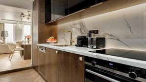 A modern kitchen with a marble countertop, built-in oven, and a coffee maker. - A BLEND OF CLASSIC PARISIAN CHARM WITH MODERN SOPHISTICATION NEXT TO THE LOUVRE (Paris)