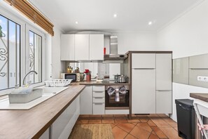 Eine moderne Küche mit weißen Schränken, einem Backofen und einem Spülbecken.