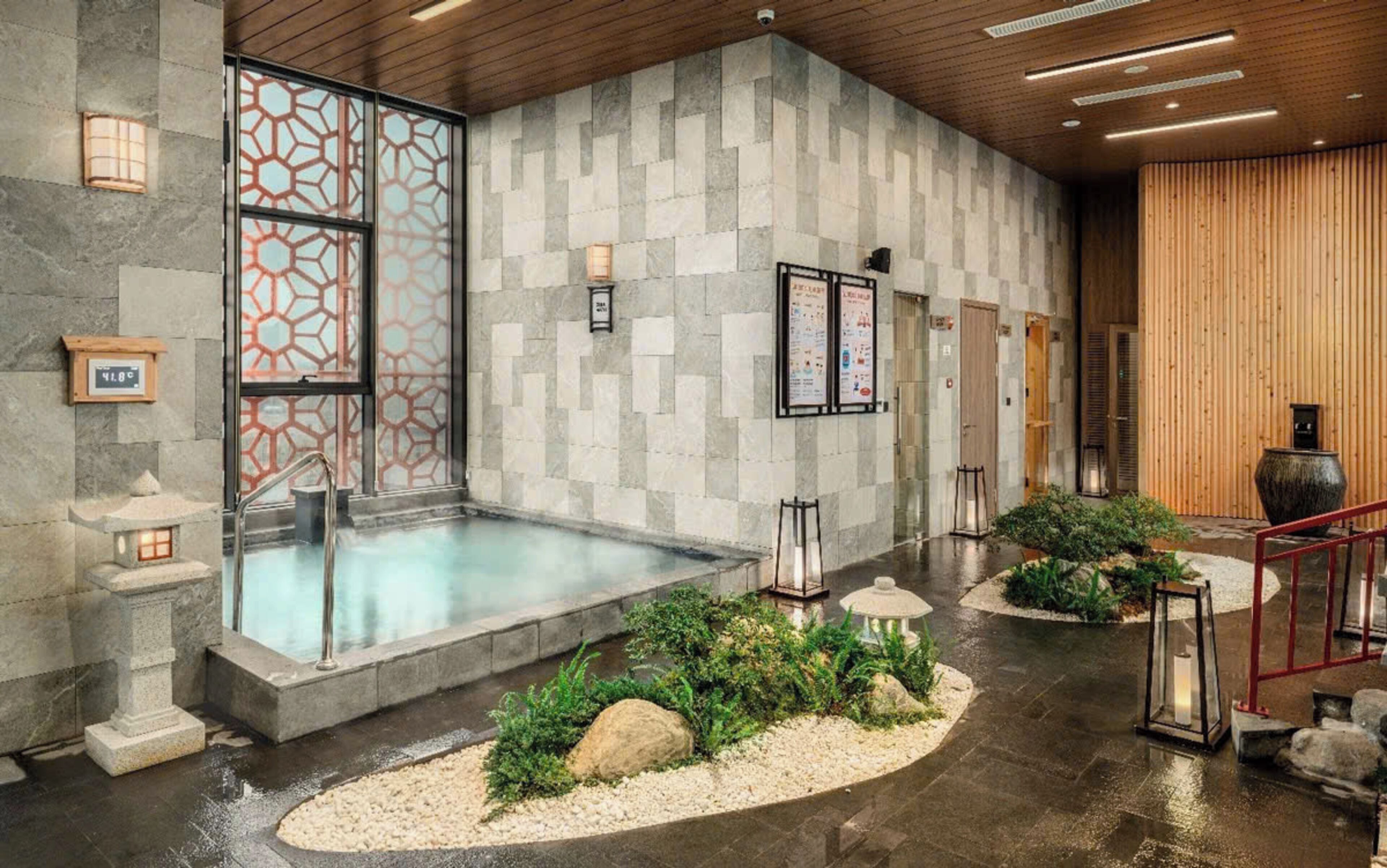 A spa area with a hot tub, stone walls, and a wooden ceiling.