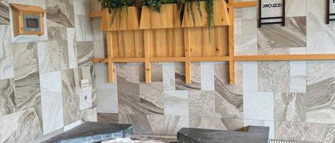 Ein Spa-Bereich mit Whirlpool, Holzregalen mit Pflanzen und einer Marmorwand.
