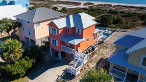 Una propiedad costera con una casa grande, una escalera destacada y una zona de piscina.