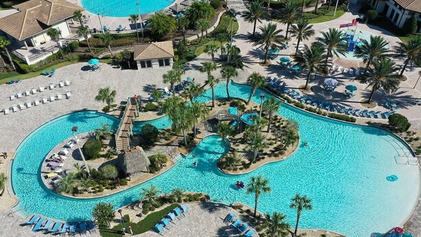 Vue aérienne d’un complexe hôtelier doté de plusieurs piscines, de palmiers et d’espaces de détente.