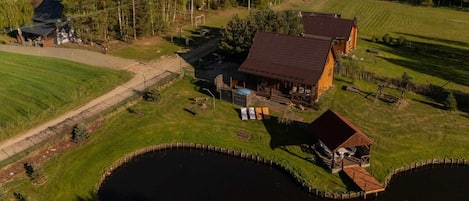 Un chalet au bord du lac, doté d’une grande terrasse et d’un petit quai.