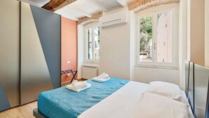 Una camera da letto moderna con un letto, un termosifone e una finestra vista esterna.