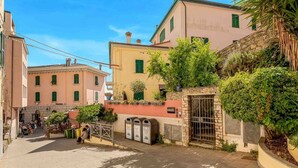 Un vicolo stretto con edifici su entrambi i lati, un muro di pietra e un cancello.