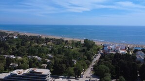 Uma área costeira com praia, edifícios residenciais e uma estrada que leva à praia.