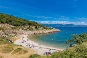 A beach with clear water, rocky terrain, and greenery. - Holiday house ALYSSA with pool on Krk island, 3km from sand beach (Vrbnik)