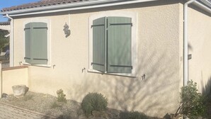 A two-story building with a beige stucco exterior, green shutters, and a tiled roof. - Detached Family Villa in Les Cammazes (Les Cammazes)