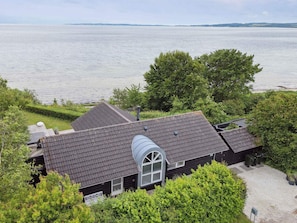 Uma casa com um grande salão de canto e vista para um lago.