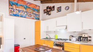 Eine moderne Küche mit gelben Schränken, einem Holztisch und einem Bild an der Wand.