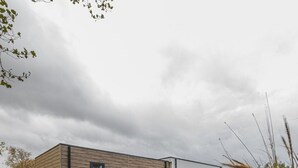 A modern building with a flat roof and a wooden facade.