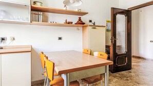 Una cucina moderna con un tavolo di legno, sedie gialle e un lampadario.