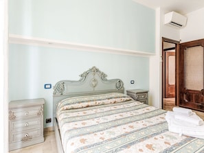 A bedroom with a bed, a nightstand, a dresser, and a door. - Wohnung 'Superior Apartment by Interhome (Albisola)