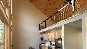 Una cocina moderna con armarios de madera, electrodomésticos de acero inoxidable y un ventanal grande.