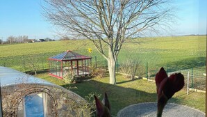 Un invernadero, un árbol y un pabellón en un entorno rural.