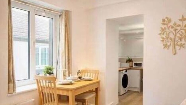 A compact living space with a dining area, kitchenette, and a sofa. - cozy one-bed apartment in the heart of Penzance (Penzance)