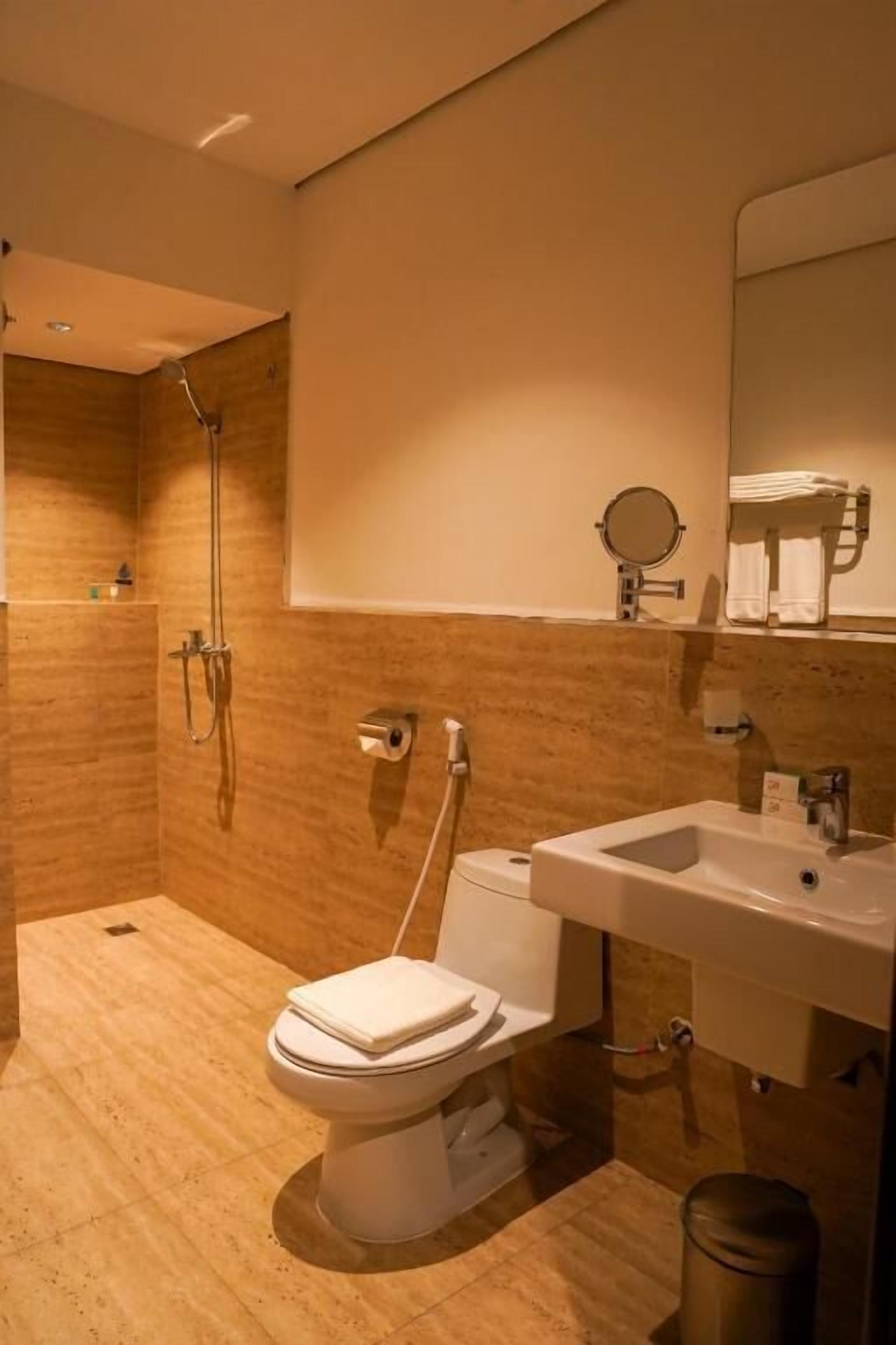 A modern bathroom with a toilet, sink, and shower.