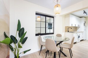 A modern kitchen with white cabinets, a black countertop, and a built-in washing machine. - Home2Book Stylish Studio by the Sea Los Cristianos (Los Cristianos)
