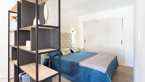 A bedroom with a bed, a wardrobe, and a shelf unit. - Home2Book Stylish Studio by the Sea Los Cristianos (Los Cristianos)