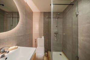 Ein modernes Badezimmer mit Badewanne, Toilette und Dusche.