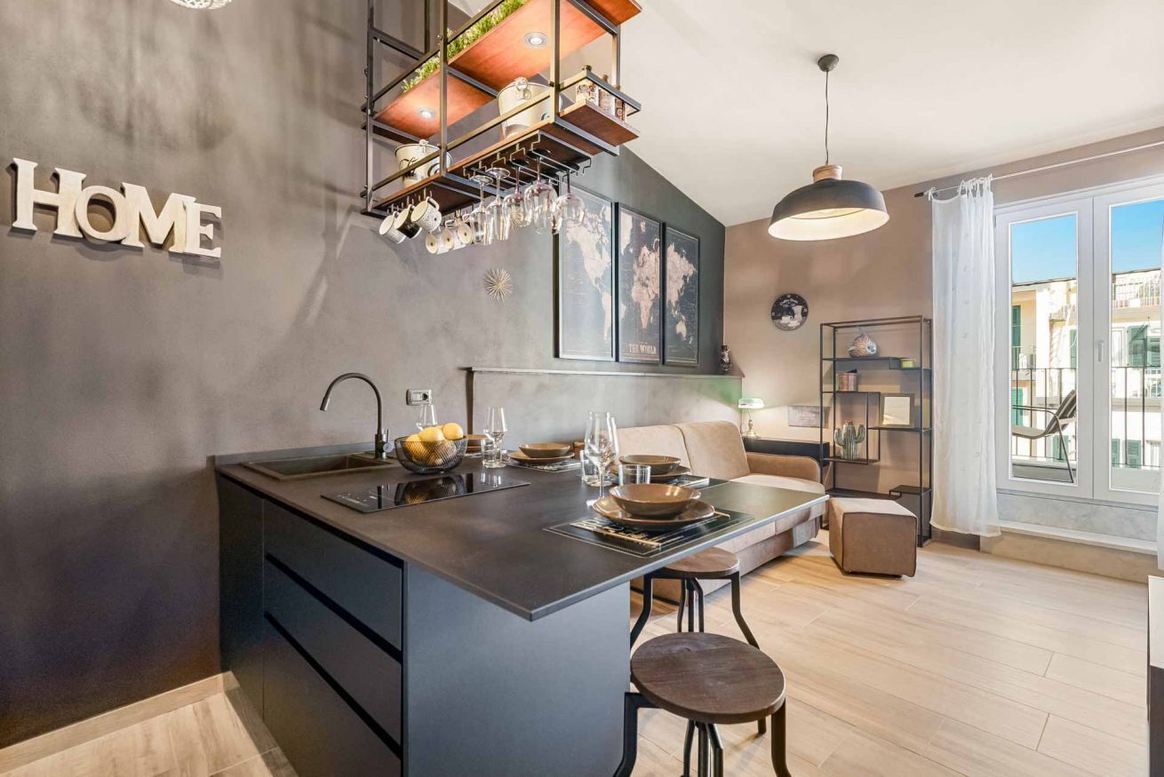 Une cuisine moderne dotée d’un îlot central, d’un coin repas avec un canapé et d’une vue sur l’extérieur.