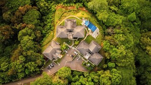 Vista aérea de un barrio residencial con varias casas, una piscina y un césped bien cuidado.