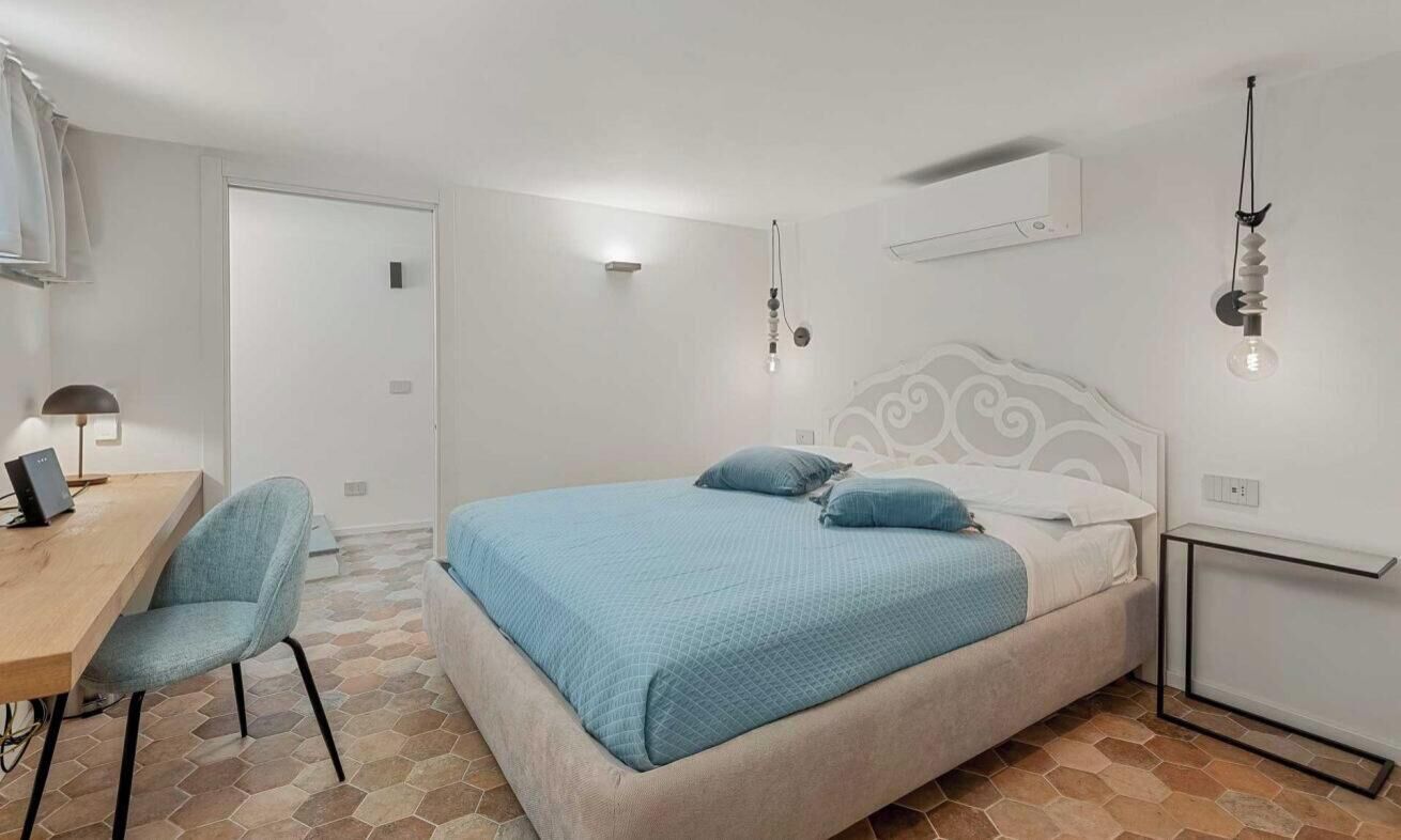 Ein Schlafzimmer mit einem Bett, einem Schreibtisch und einem Stuhl.