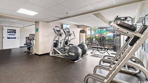 Ein Fitnessstudio mit Laufbändern, Kraftgeräten und einer Hantelbank.