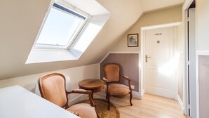 Ein Zimmer mit einem Oberlicht, einem runden Tisch, zwei Stühlen und einer Tür.