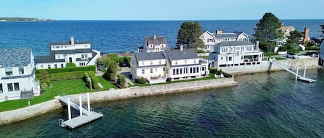 A waterfront property with multiple houses, a dock, and a pier.