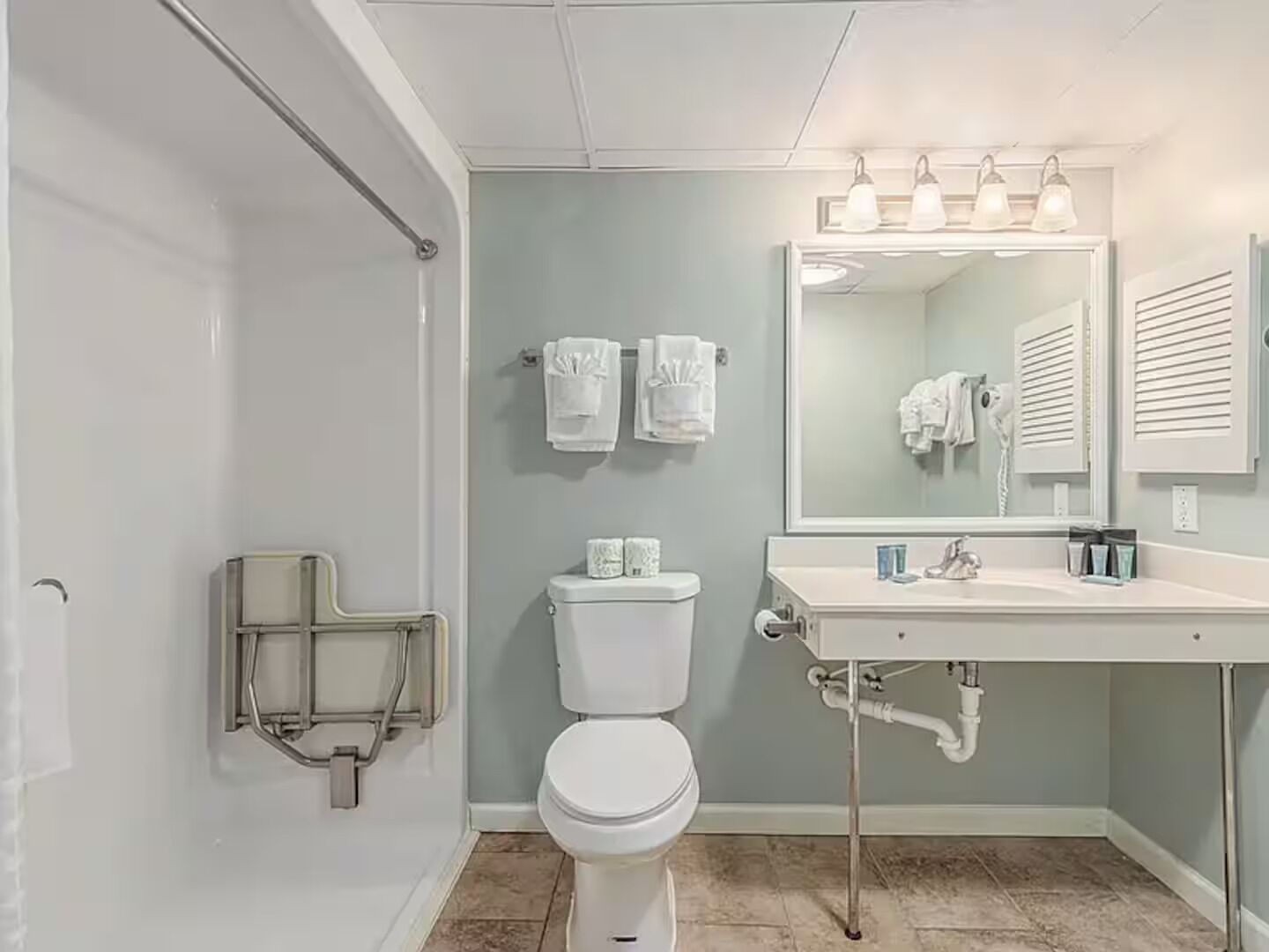 A bathroom with a toilet, sink, and shower area.