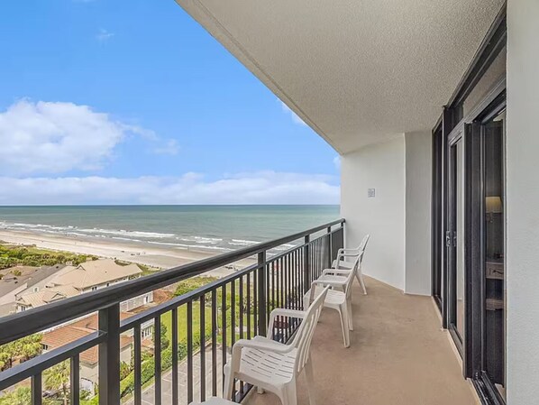 Ein Balkon mit Blick auf Strand und Meer.
