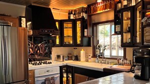 A modern kitchen with a large island, stainless steel appliances, and a wine rack.