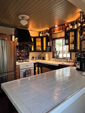 A modern kitchen with a large island, stainless steel appliances, and a wine rack.