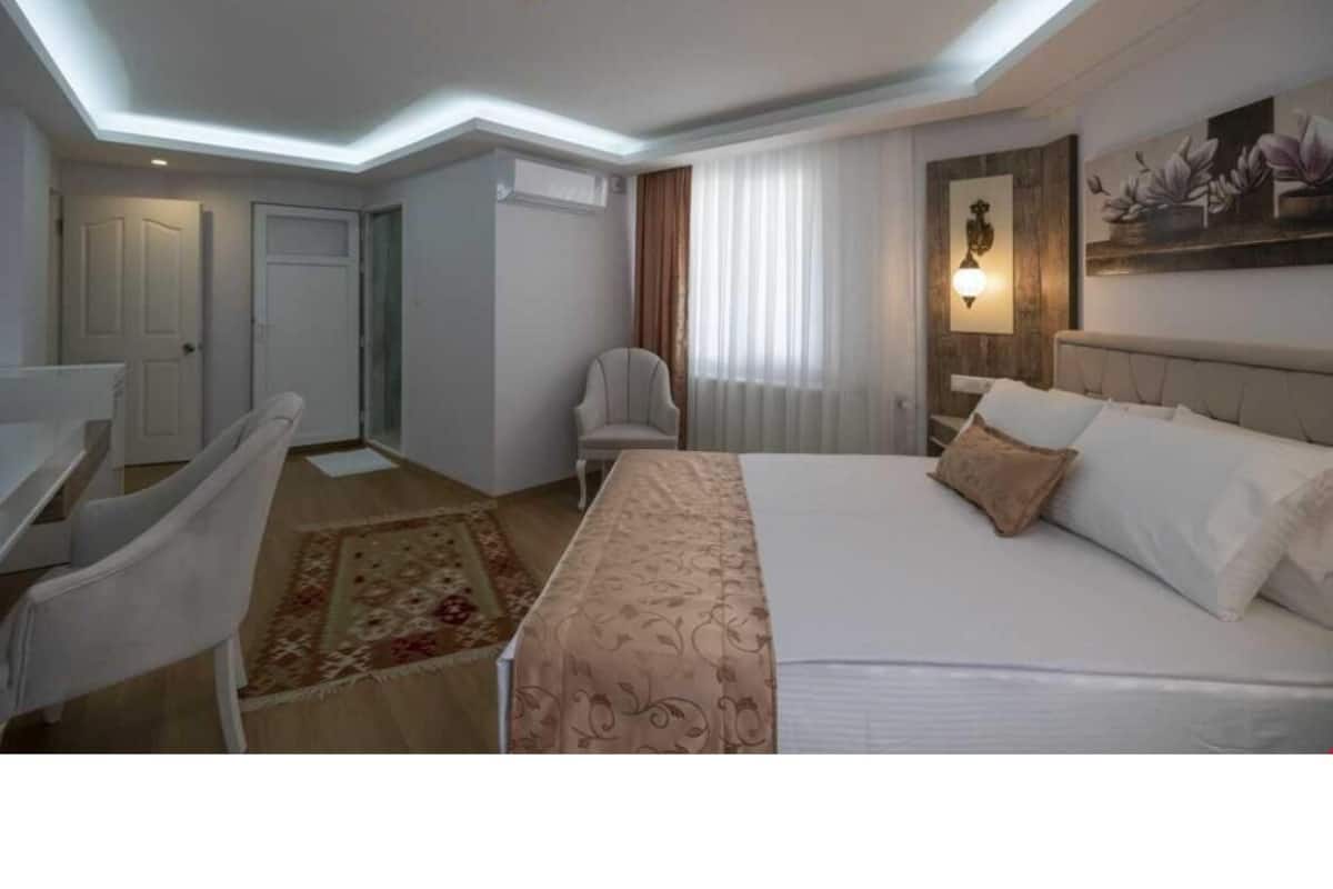 Una camera d'albergo moderna con un letto, una scrivania, una sedia e un tavolino.