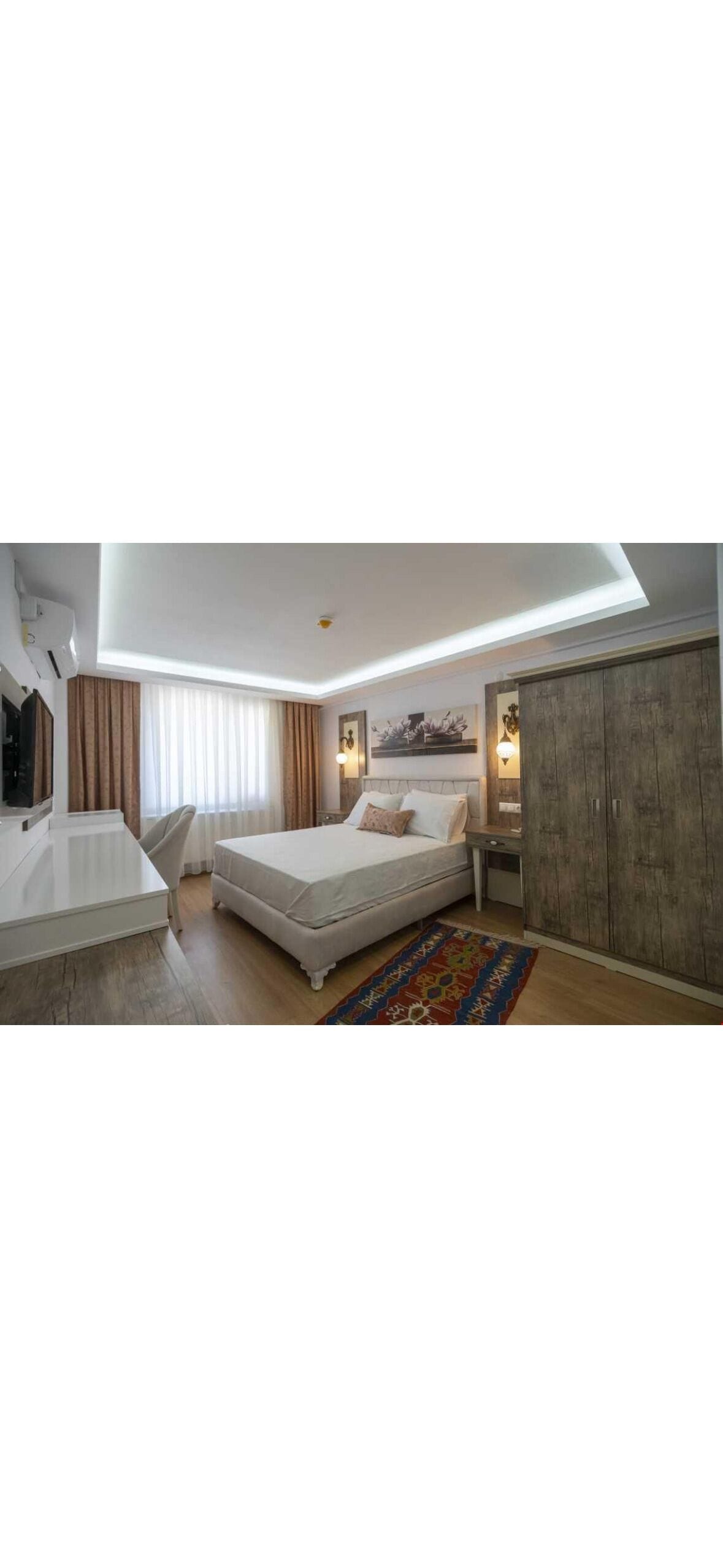Una habitación de hotel moderna con una cama, un escritorio y un armario.