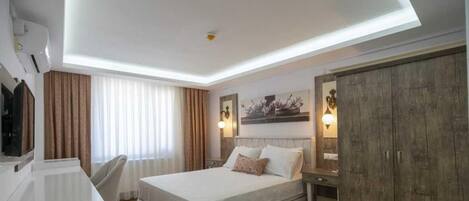Una habitación de hotel moderna con una cama, un escritorio y un armario.