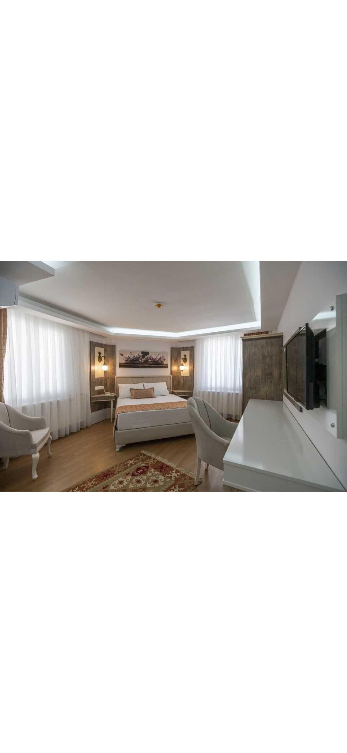 Une chambre d’hôtel moderne équipée d’un grand lit, d’un bureau, d’une chaise et d’une télévision.