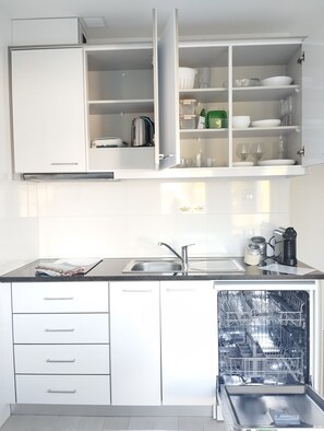 A modern kitchen with white cabinets, a stainless steel sink, and a dishwasher. - Eira da Mila - 2-bedroom house with outdoor area (Coimbra)