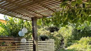 An outdoor patio with a table, chairs, and a pergola.