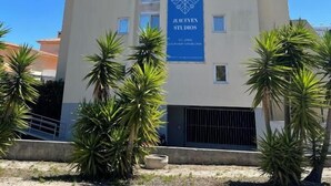A building with a blue banner reading "JUICEVEN STUDIOS" and a chimney. - Juiceven Studios (Cascais)