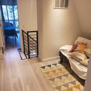A bedroom with a bed, a small rug, and a window with blinds. - Charming 2-bedroom A Frame modern cabin in McCall perfect for a cozy getaway (McCall)