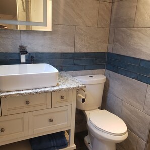 A bathroom with a white sink, a toilet, and a mirror above the sink. - Charming 2-bedroom A Frame modern cabin in McCall perfect for a cozy getaway (McCall)